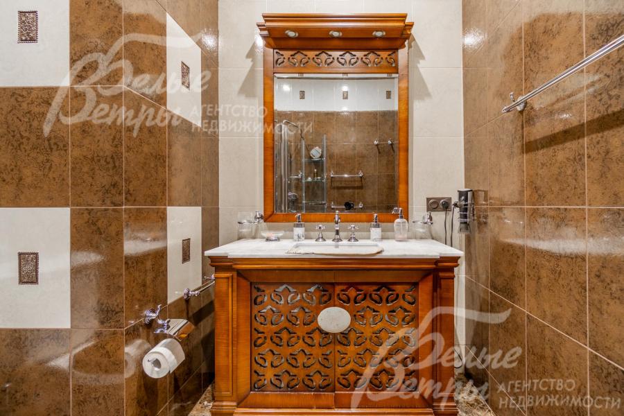 Раковина интегрирована в тумбу с зеркалом из массива дерева