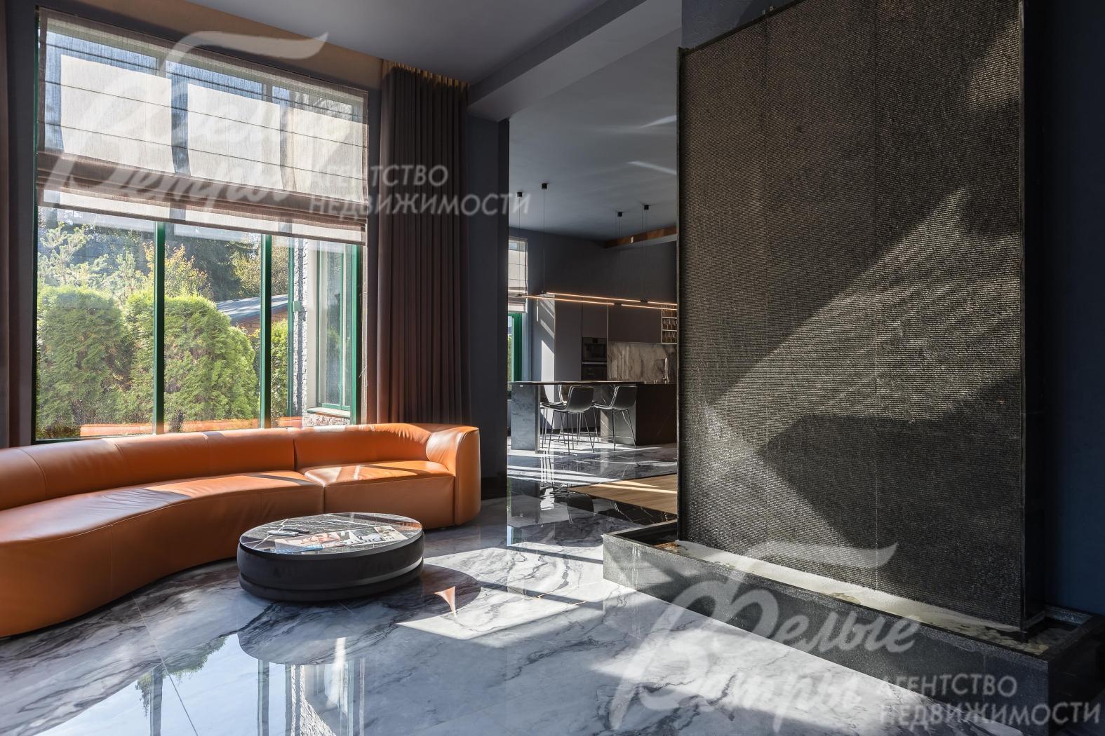 В зоне ТВ обустроен уютный уголок с кожаным диваном, с водяной стеной‑водопадом