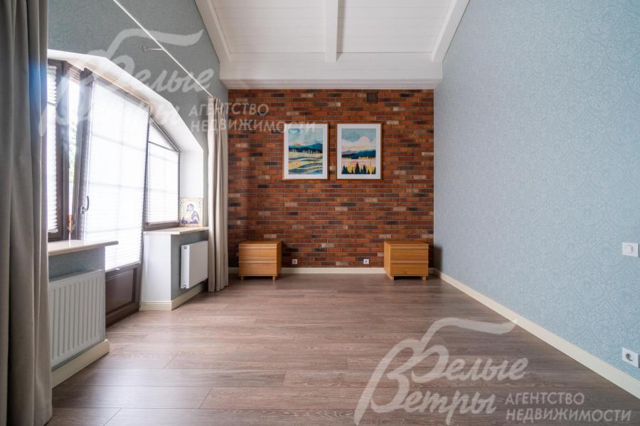 Спальня на втором этаже с декоративной кирпичной стеной и выходом на террасу