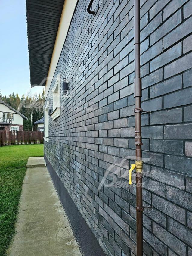 Стены 1го этажа облицованы термопанелями с темной плиткой под искусственный камень.