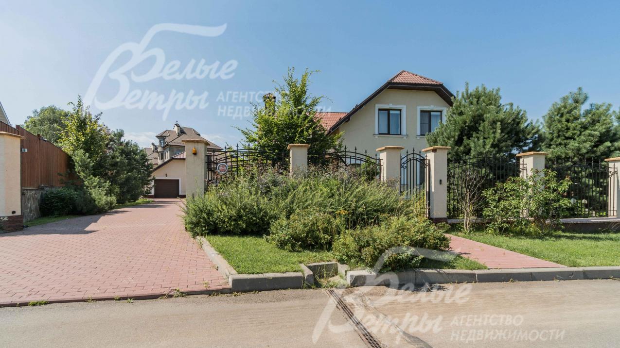 Участок огорожен спереди прозрачным, кованым забором на каменных столбах с бетонным цоколем