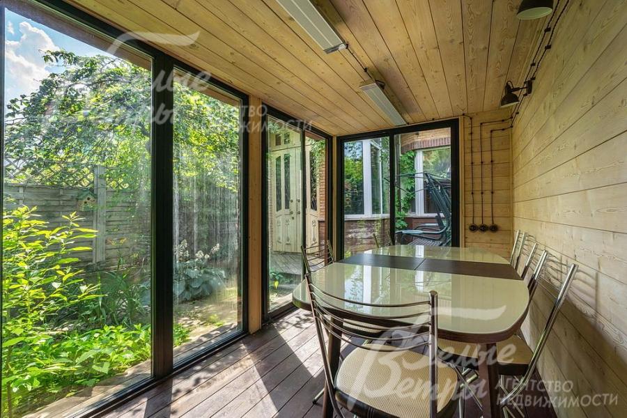 Веранда с панорамными окнами и зоной отдыха.