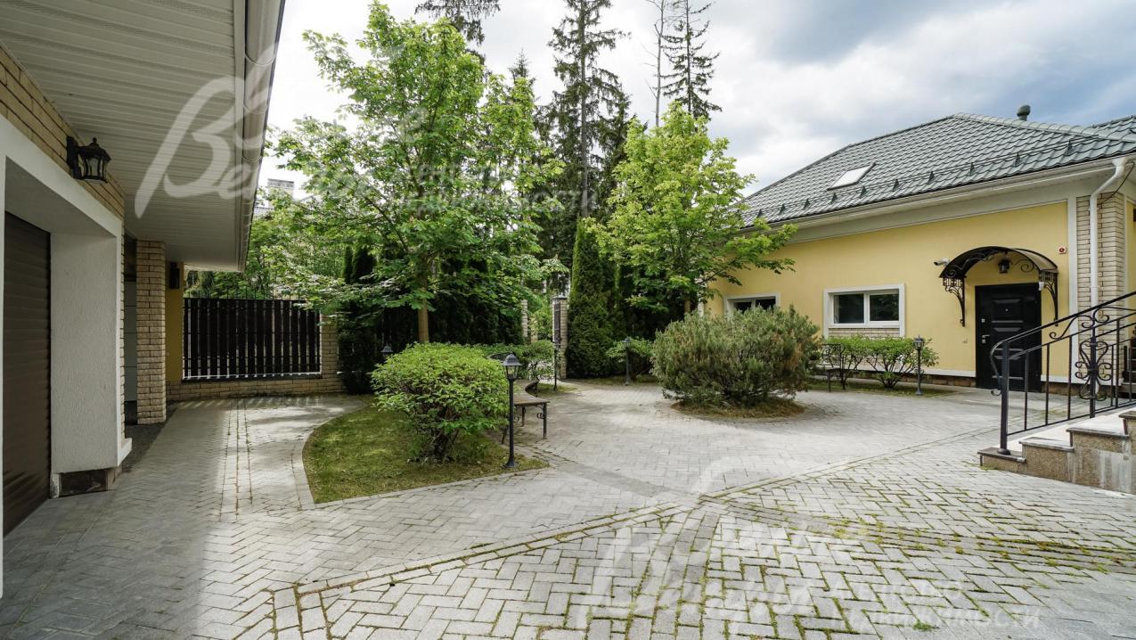 Оригинальная площадка перед домом, со скамейками, вымощенная плиткой