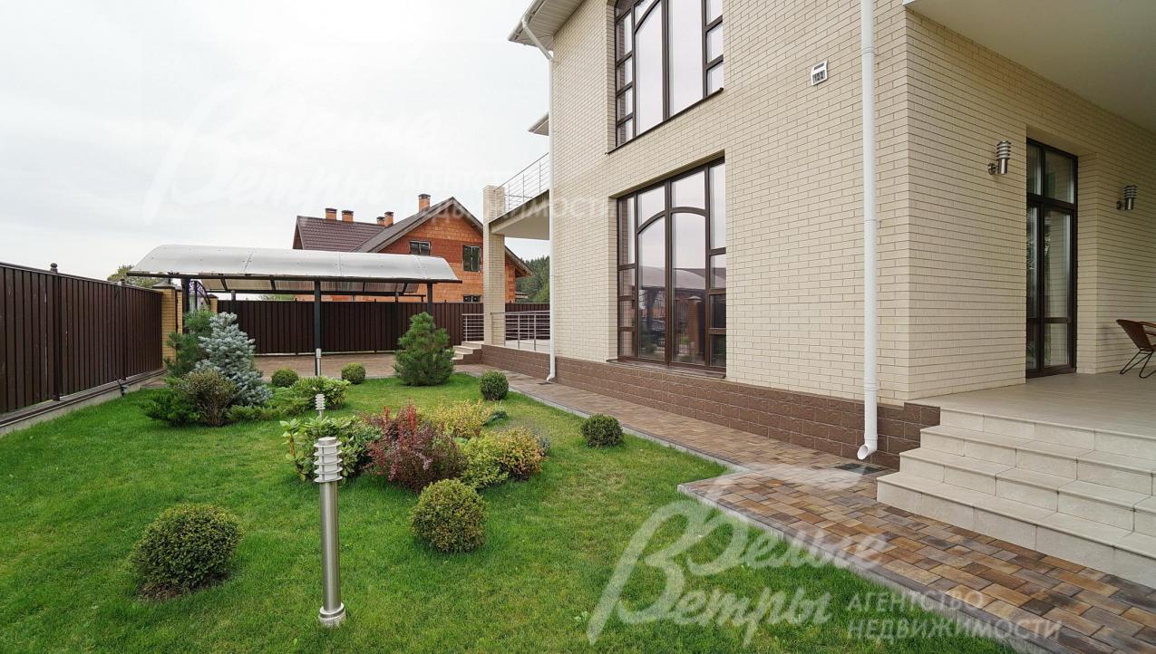 На участке обустроен газон, уличное освещение и вымощены плиткой дорожки