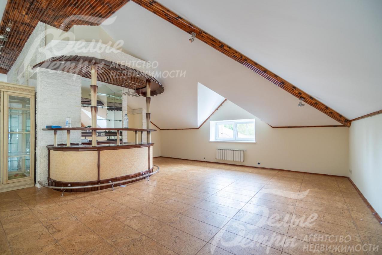 Холл на мансардном этаже с баром и шкафом со стеклянными дверцами