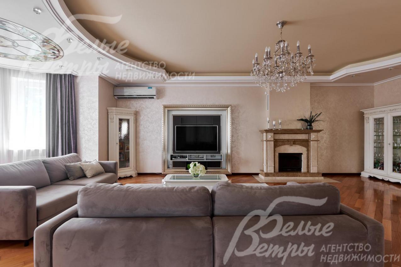 В гостиной установлен широкоформатный телевизор напротив диванной группы