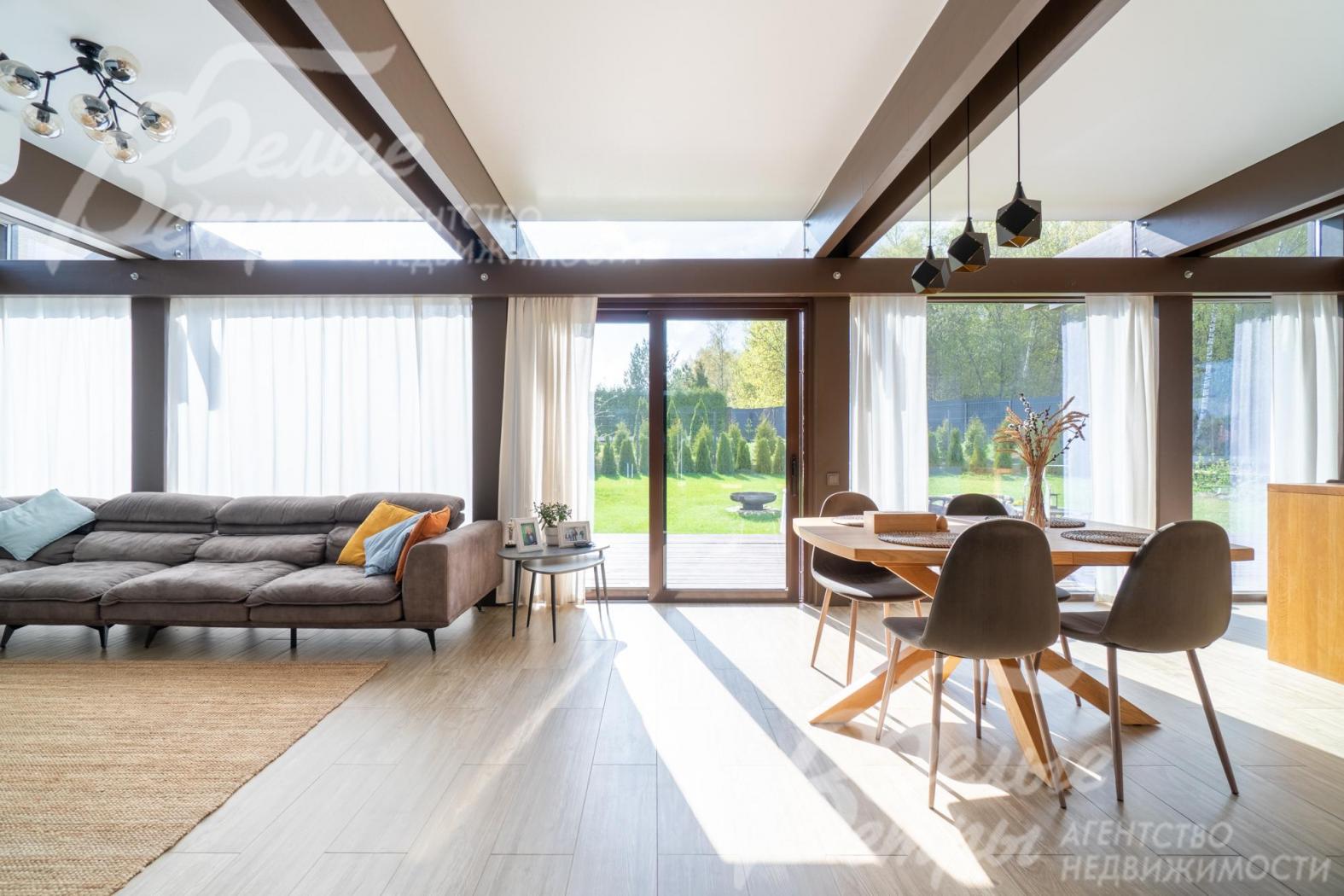 Объединенное пространство кухни-столовой и гостиной, визуально разделено зонированием