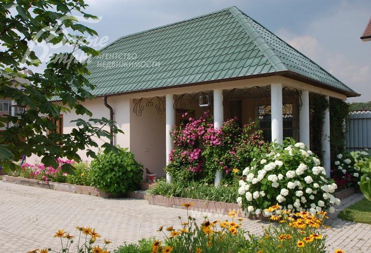 Летняя кухня с зоной барбекю утопает в цветах