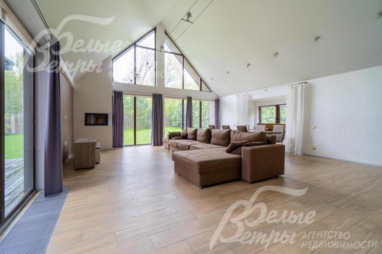 В гостиной панорамное остекление по двум стенам, выход на террасу