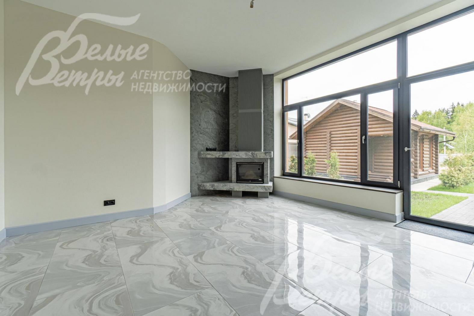 Зона гостиной с камином и панорамным остеклением