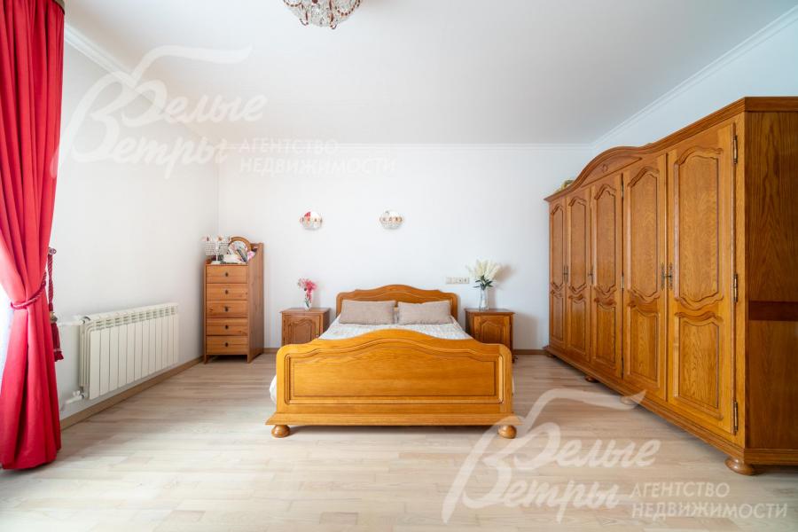 В спальне - вместительный шкаф и кровать из массива дерева в классическом стиле