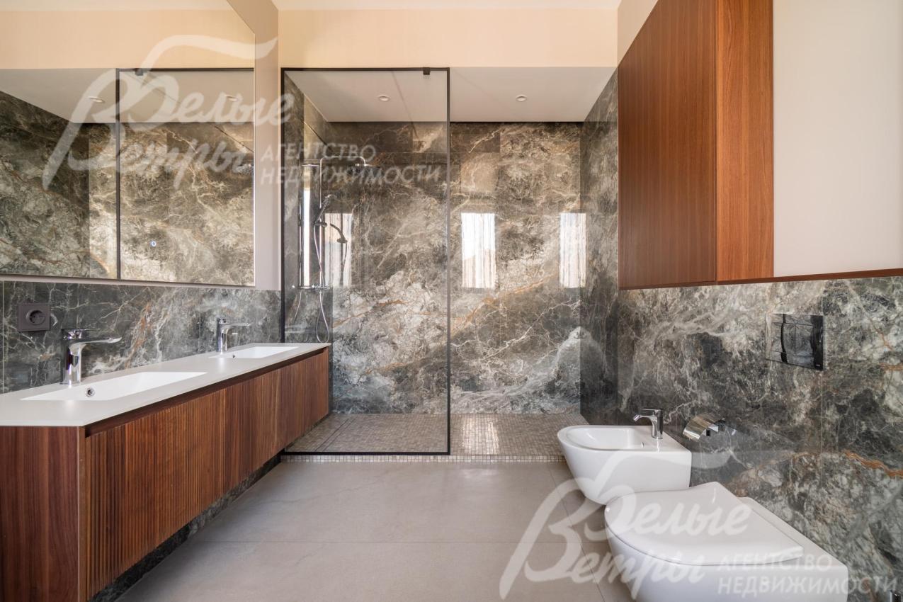 Санузел на втором этаже, в отделке которого сочетаются благородная природная фактура и лаконичные геометрические формы
