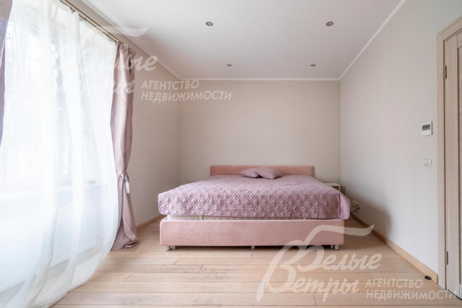 Одна из спален на втором этаже с собственным санузлом и большим окном