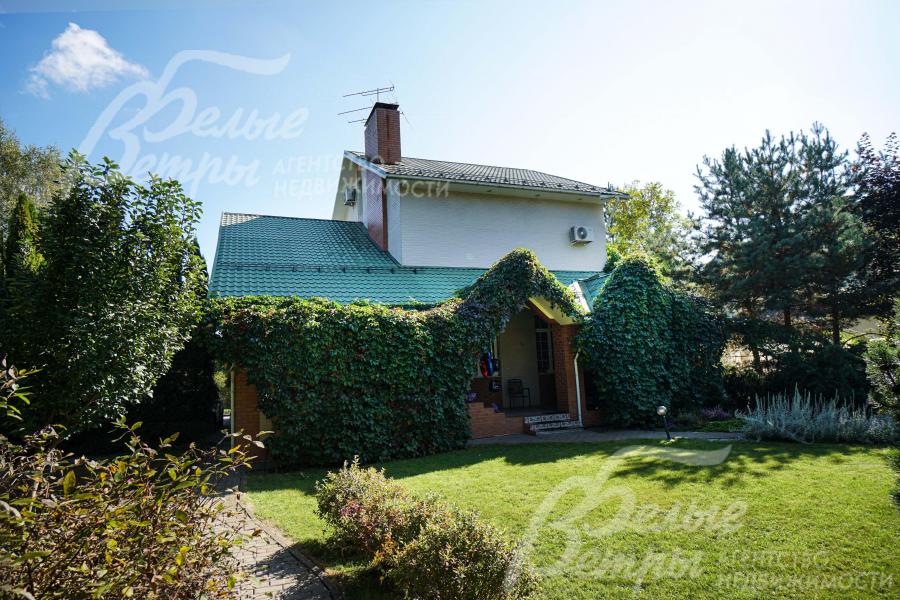 Перед одним из выходов из дома - ровная зелёная лужайка с газоном