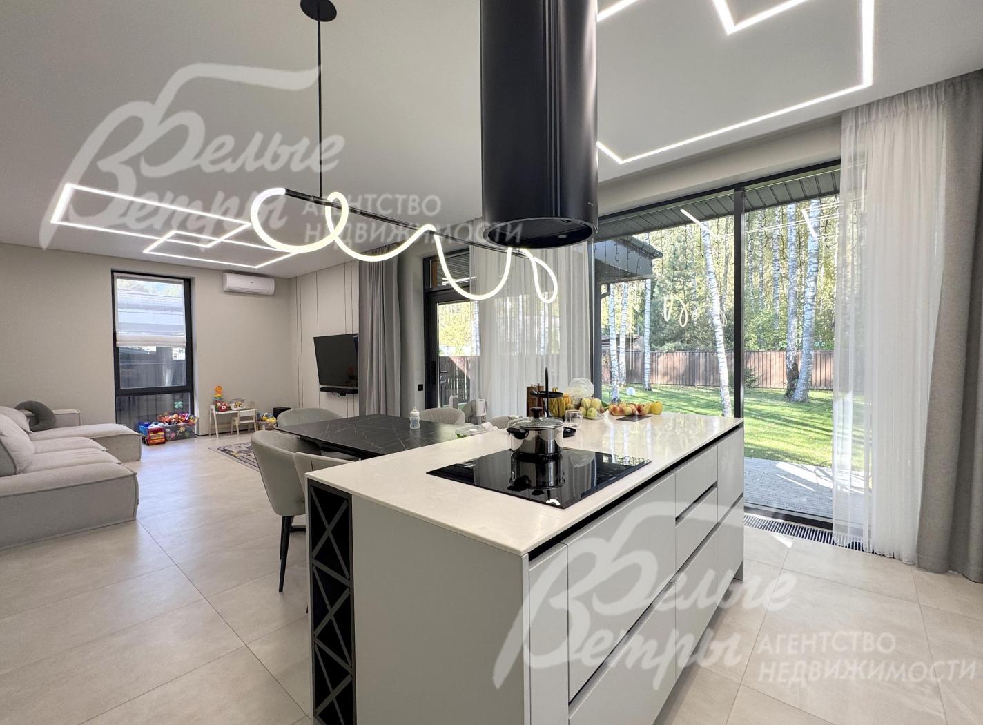 На кухне – гарнитур в трендовом цветовом решении с островом («Стильные Кухни»), столовая группа, техника