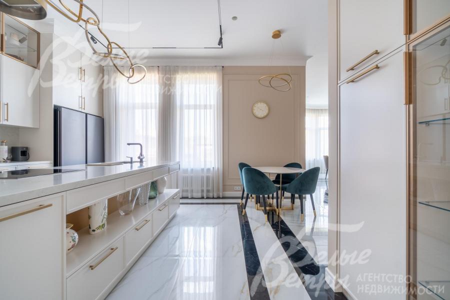 На кухне установлен гарнитур молочного цвета с фасадами МДФ и шкаф-витрина