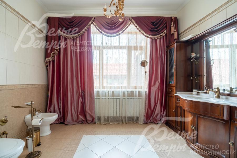 Просторный санузел мастер-спальни с душевой и мебелью из массива дерева