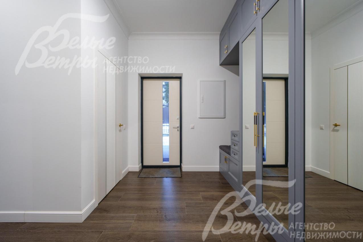 Вход в дом - дверь со стеклом и большая прихожая 