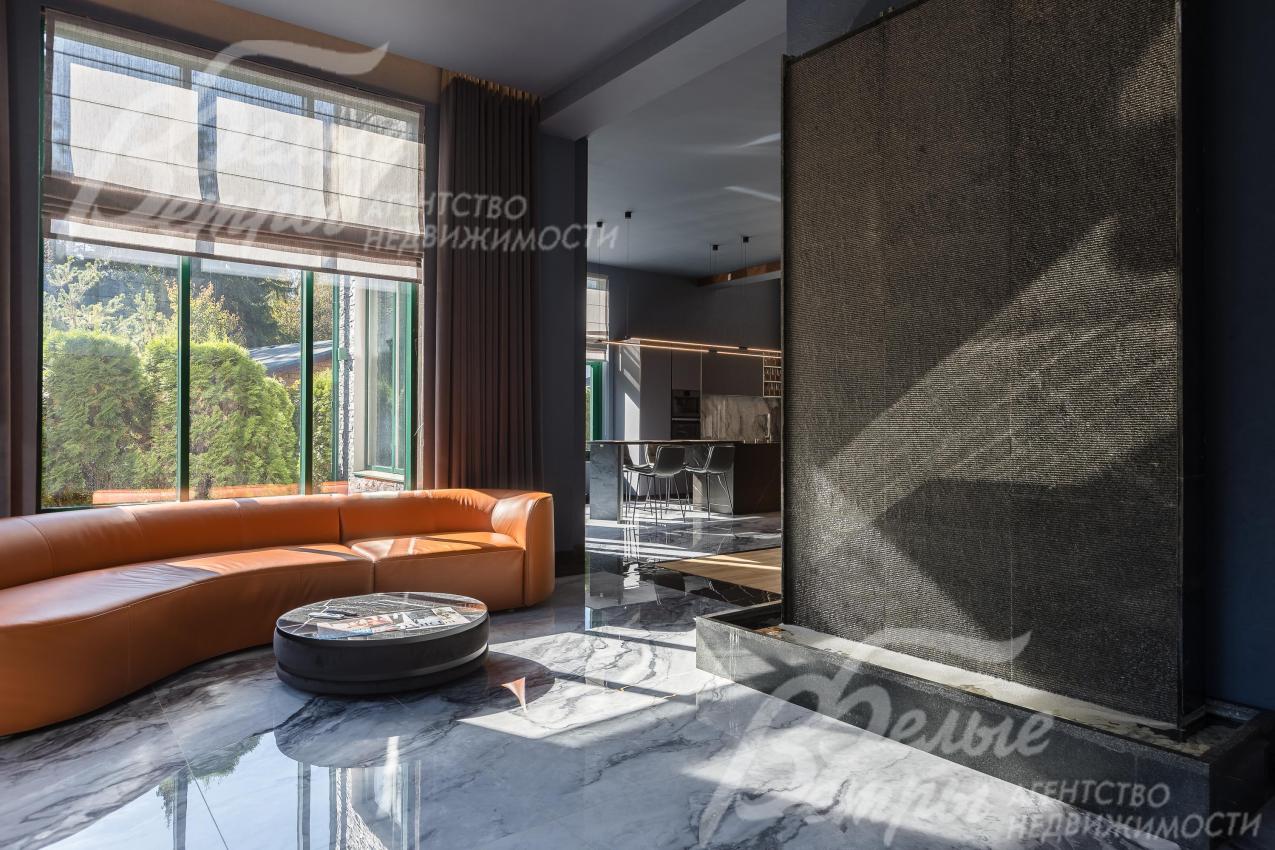 В зоне ТВ обустроен уютный уголок с кожаным диваном, с водяной стеной‑водопадом