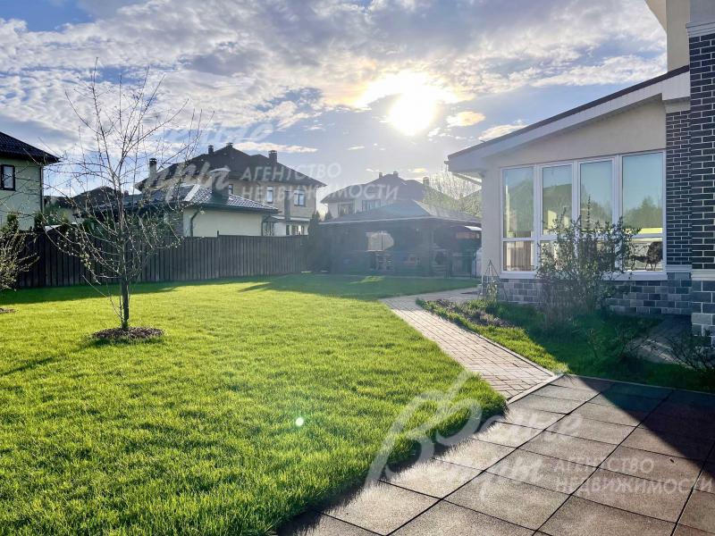 Ухоженный газон на участке, дорожки.