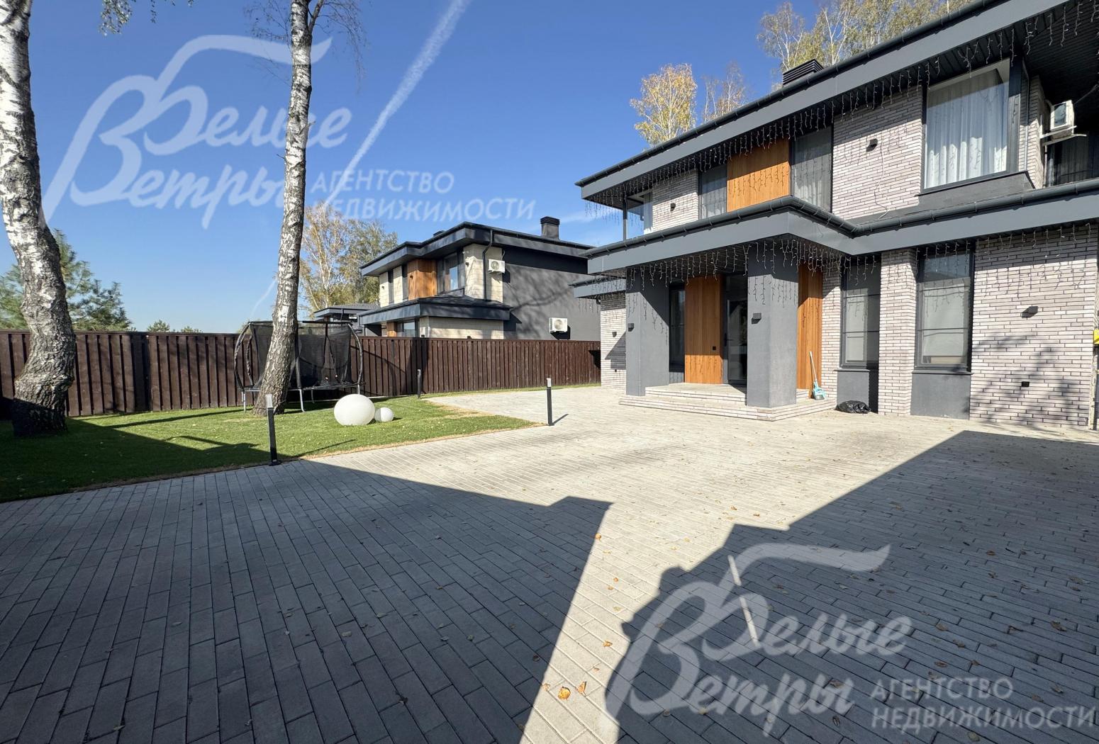 Просторная парковка у дома выложена брусчаткой на бетонном основании