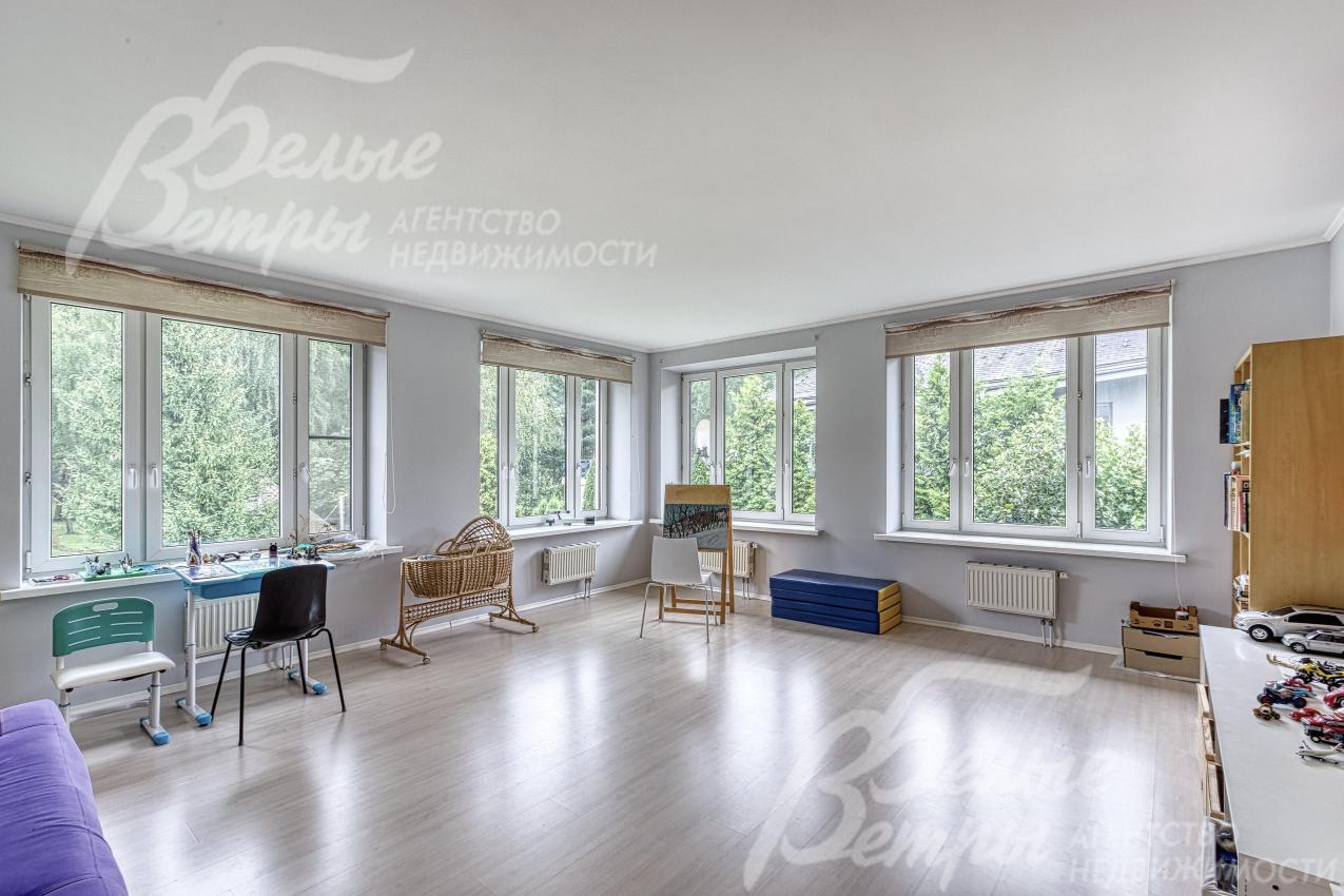 Во второй гостиной - большая площадь остекления: из окон открывается красивый вид на участок и лес