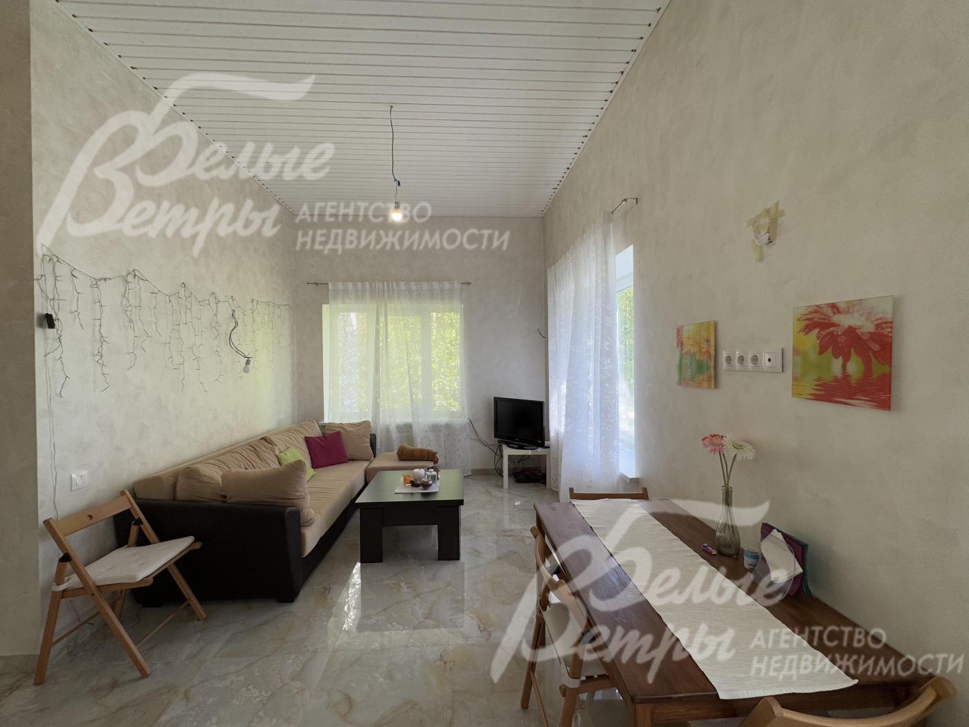 Большие окна в гостиной наполняют помещение светом и открывают обзор на участок