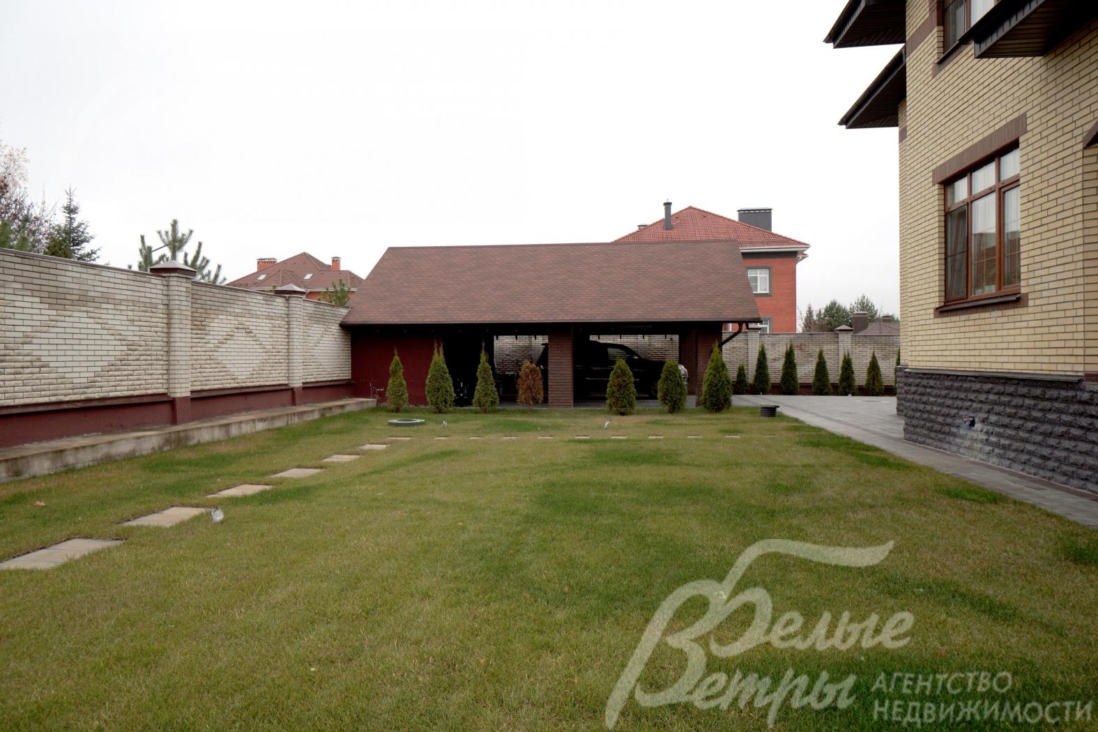 На участке высажены туи и крупномерные сосны