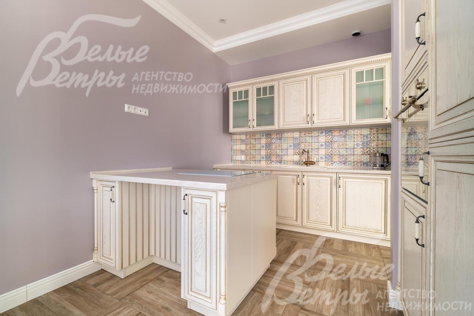 В кухне – гарнитур молочного цвета в классическом стиле с островом (бренд премиум-класса STORMER D'ART)