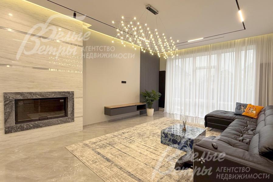 Гостиная на первом этаже дома. Благодаря панорамному остеклению и высоким потолкам помещения дома наполнены естественным светом и ощущением простора