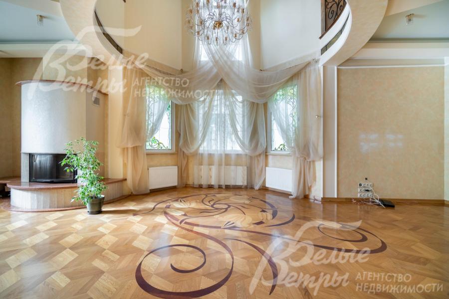 Гостиную со вторым светом украшает камин (слева), художественный паркет