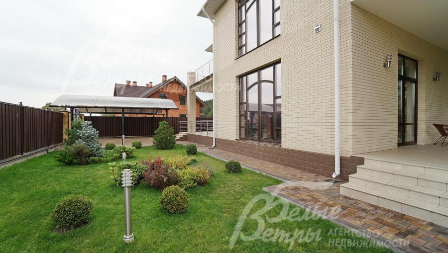 На участке обустроен газон, уличное освещение и вымощены плиткой дорожки