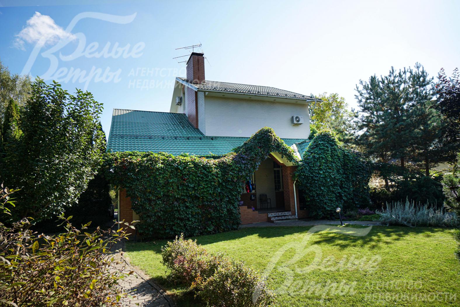 Перед одним из выходов из дома - ровная зелёная лужайка с газоном