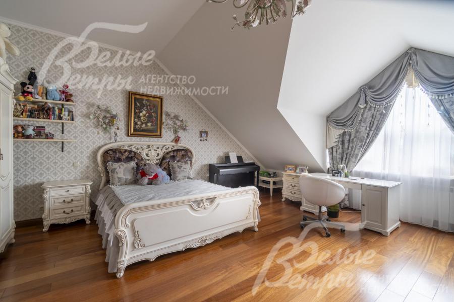 Одна из спален на втором этаже в светлых тонах со спальным гарнитуром и рабочим местом