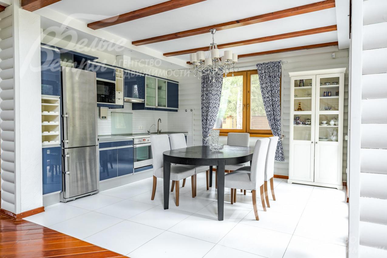 В кухне-столовой установлен стильный кухонный гарнитур со встроенной бытовой техникой