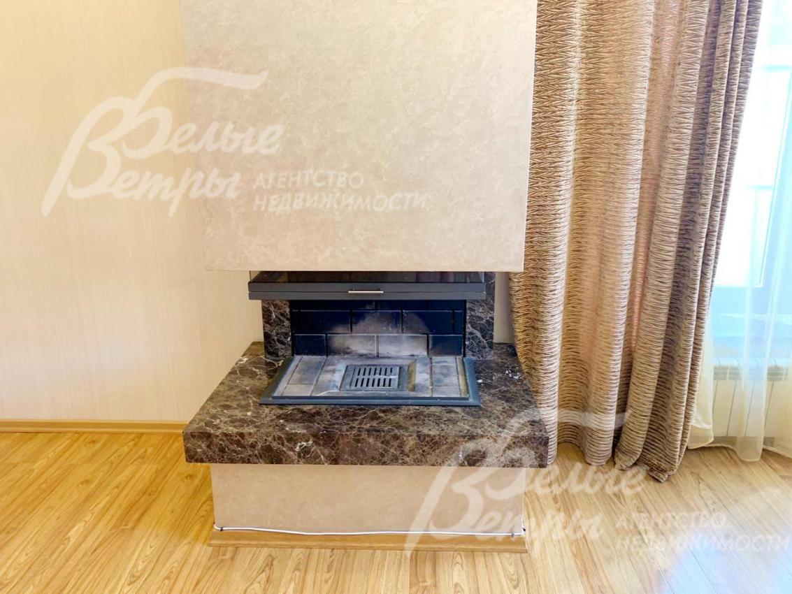 В гостиной трехсторонний камин с камерой гильотинного типа, отделанный мрамором Imperador