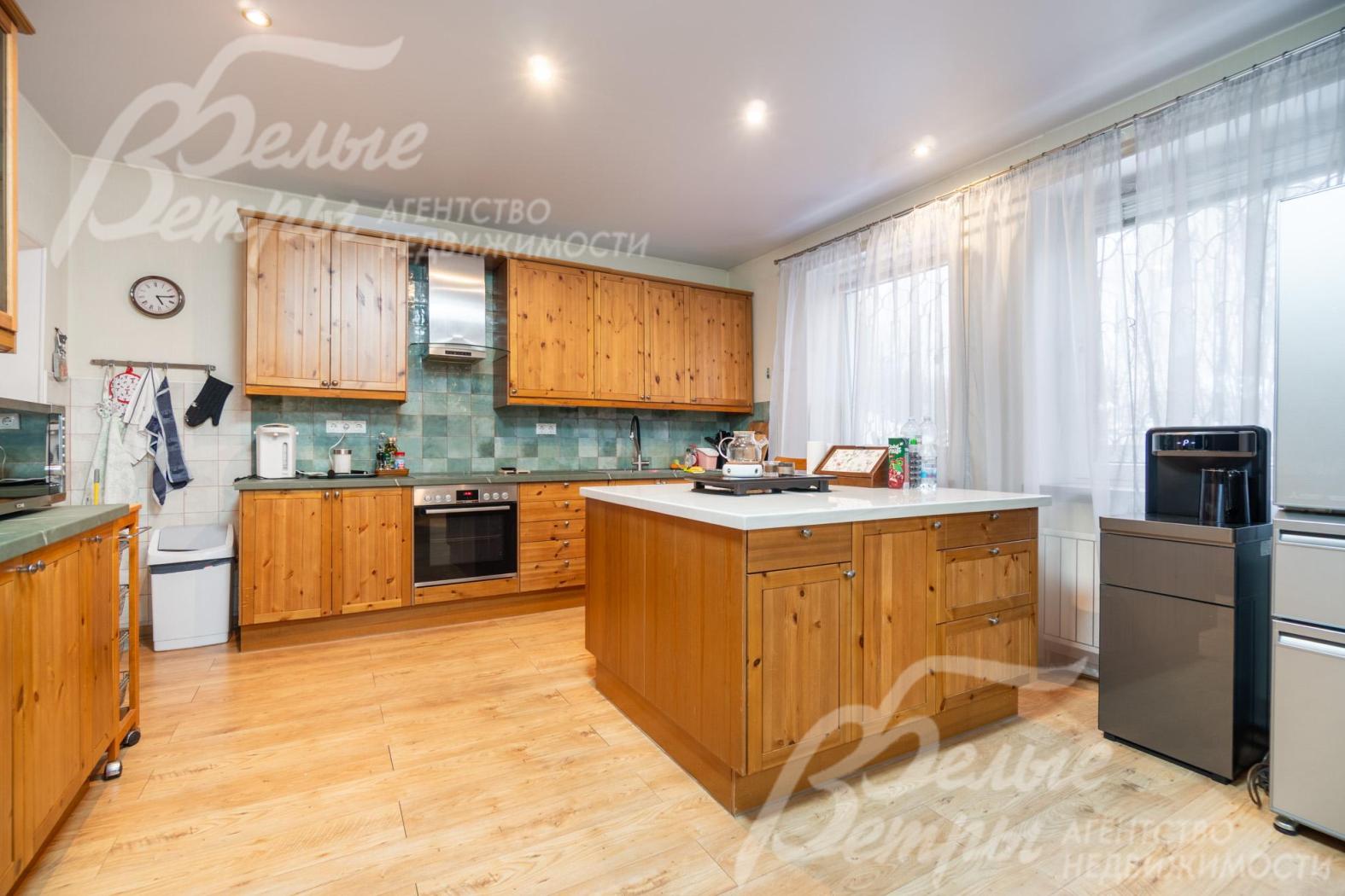 На кухне располагается гарнитур из массива дерева с островом и встроенной бытовой техникой BOSCH