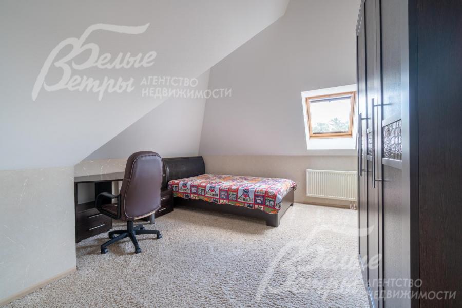 Спальня на мансардном этаже с рабочим столом и спальным гарнитуром