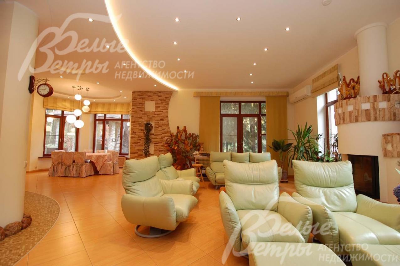 Гостиная 40 кв.м с камином. Тут разместились удобные кожаные вращающиеся кресла, благодаря которым можно легко выбрать, любоваться ли огнем в камине или смотреть интересный фильм по телевизору, или же наблюдать за играющими  в гостиной детьми.