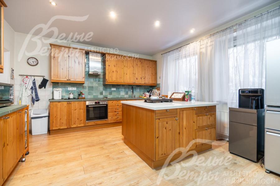 На кухне располагается гарнитур из массива дерева с островом и встроенной бытовой техникой BOSCH