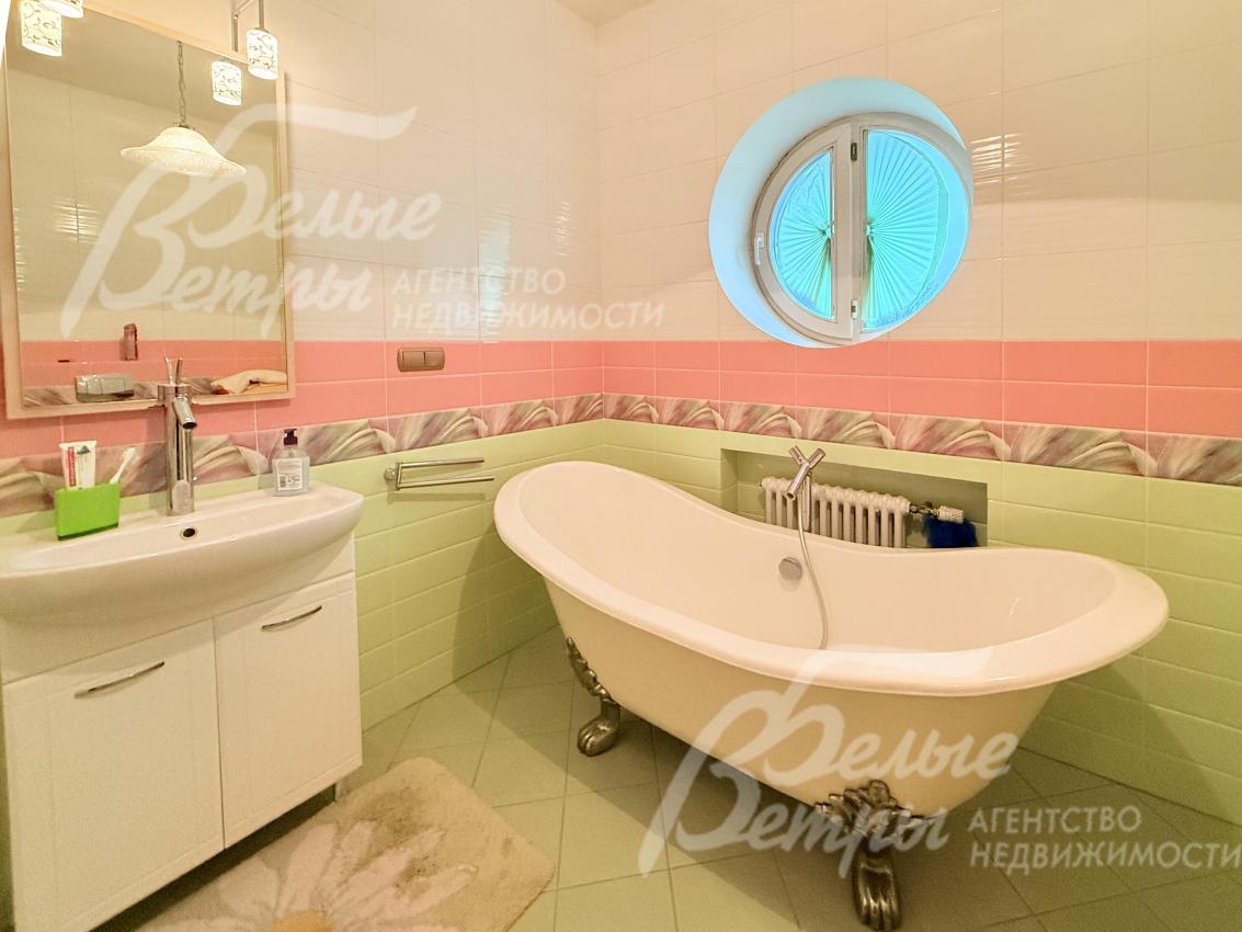 В санузле на втором этаже у окна стоит ванна овальной формы с декоративными ножками с бронзовой отделкой