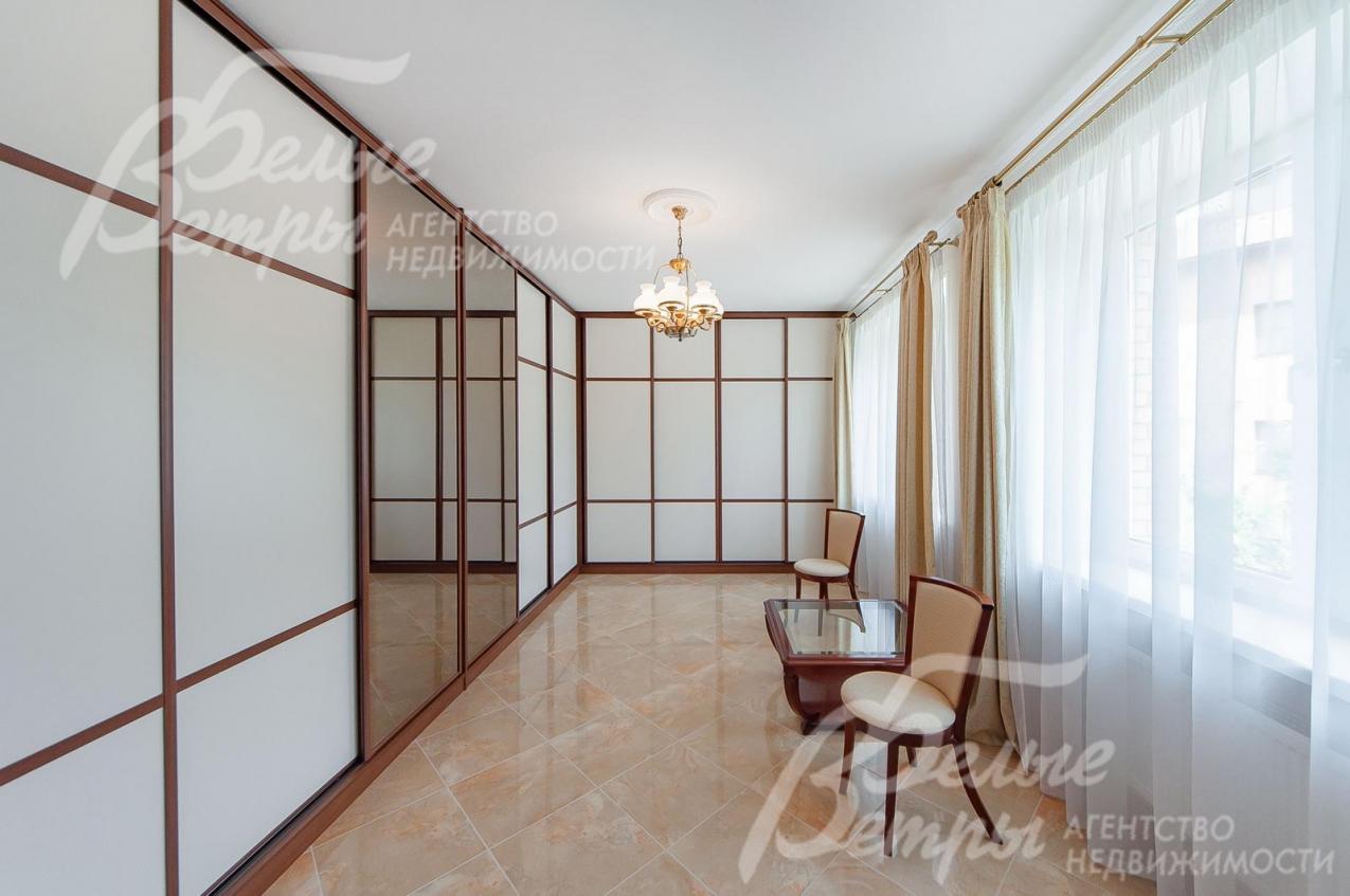 Большая гардеробная с различными системами хранения.