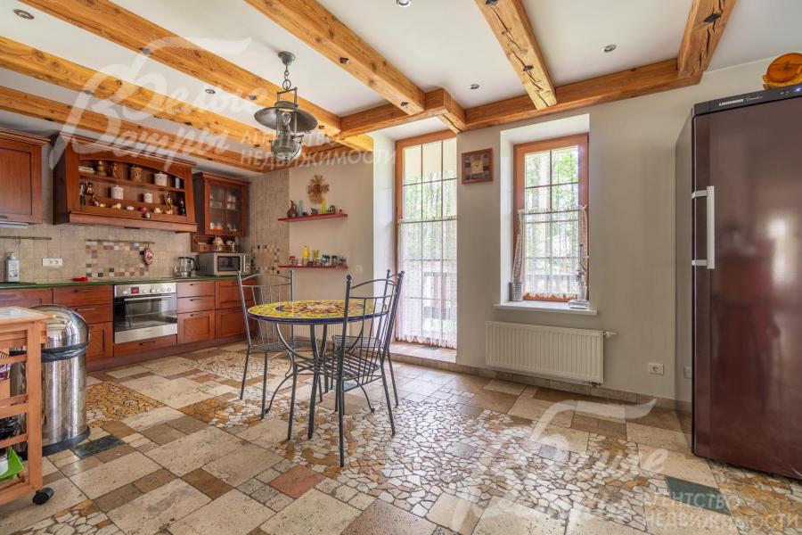 На кухне - гарнитур с фасадами из массива дерева (вишня), встроенная бытовая техника, дизайнерский обеденный стол