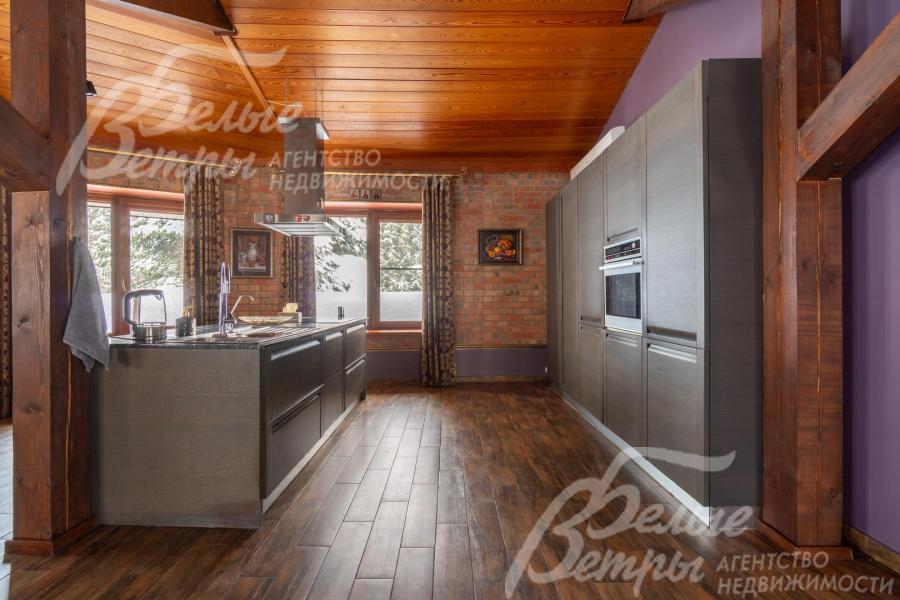 На кухне установлен гарнитур в современном стиле с лаконичным дизайном с островом