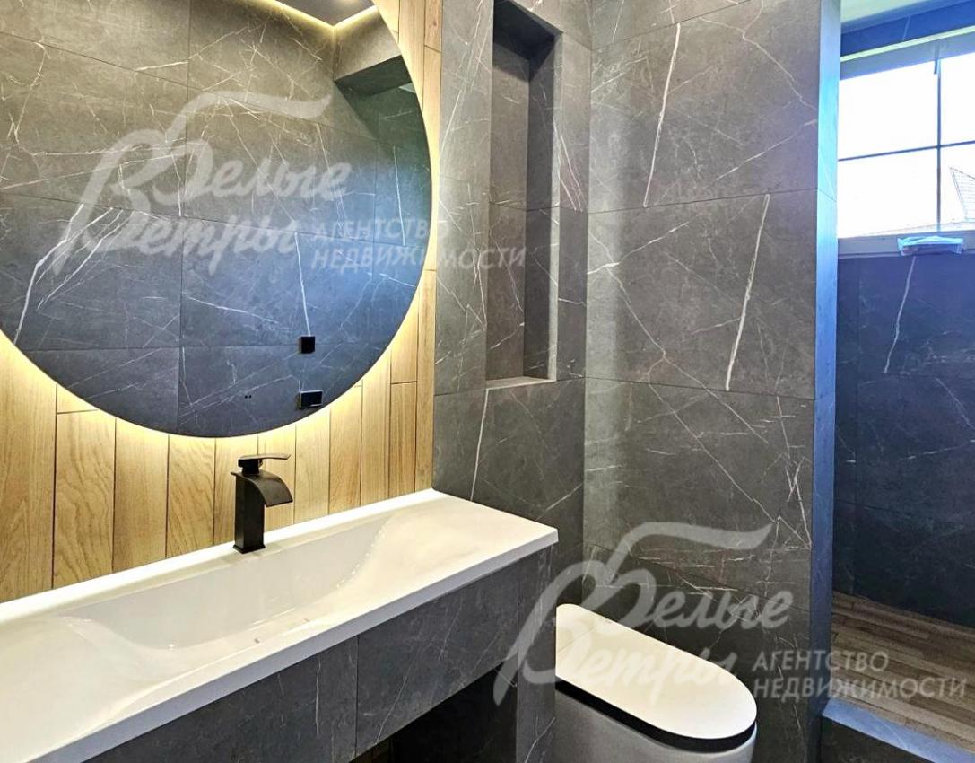 Санузел на первом этажей: на стенах - керамогранит "под чёрный мрамор", пол - с водяным подогревом