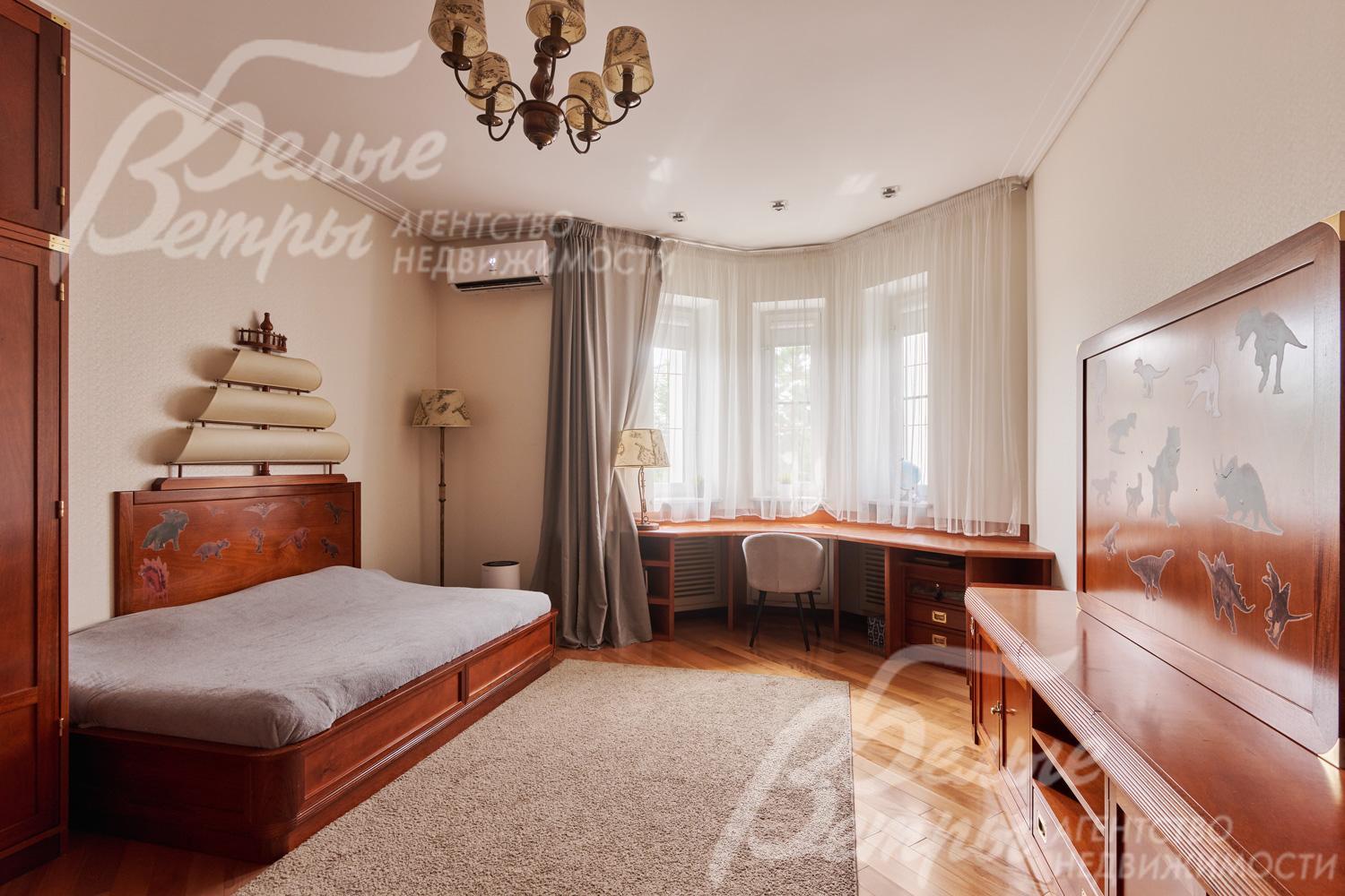 Одна из спален на втором этаже с просторным рабочим местом у окна