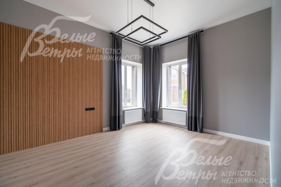 Стены комнаты на первом этаже отделаны полиуретановыми стеновыми панелями под дерево, украшает комнату изысканный светильник