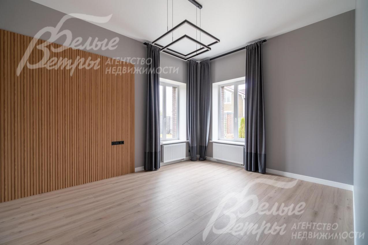 Стены комнаты на первом этаже отделаны полиуретановыми стеновыми панелями под дерево, украшает комнату изысканный светильник