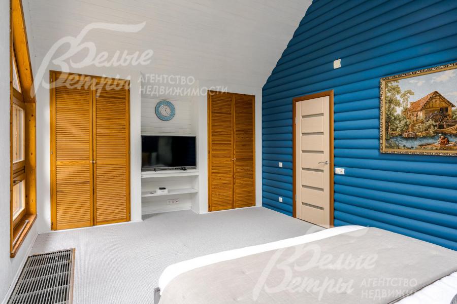 Спальня на втором этаже оборудована системой встроенных шкафов, стены частично отделаны блок-хаусом