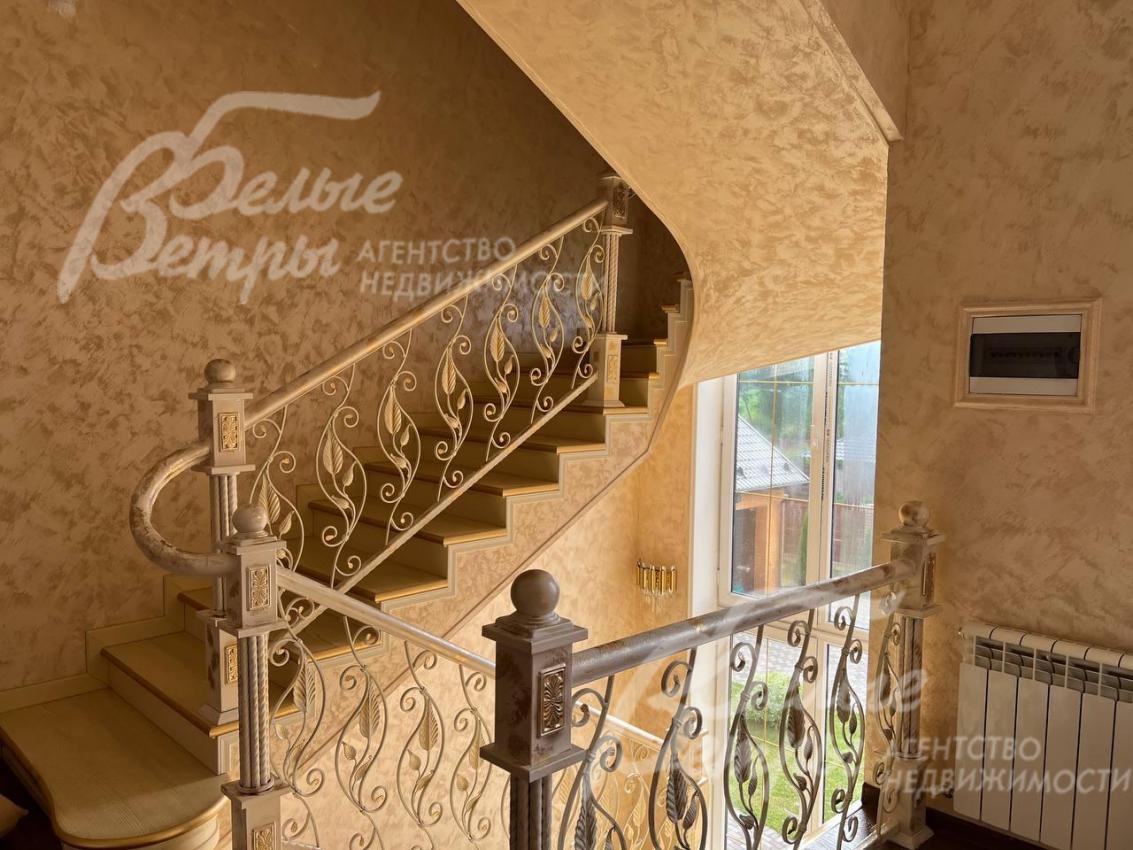 Красивая лестница с коваными перилами.